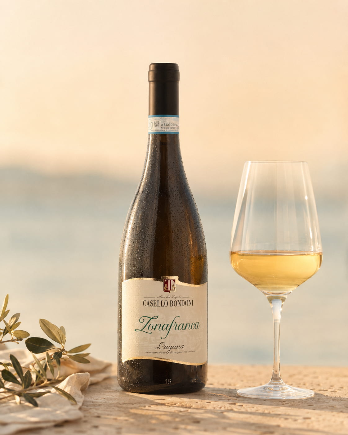 Flasche und Glas Casello Bondoni Zonafranca auf hellem Stein im warmen Gardasee-Licht