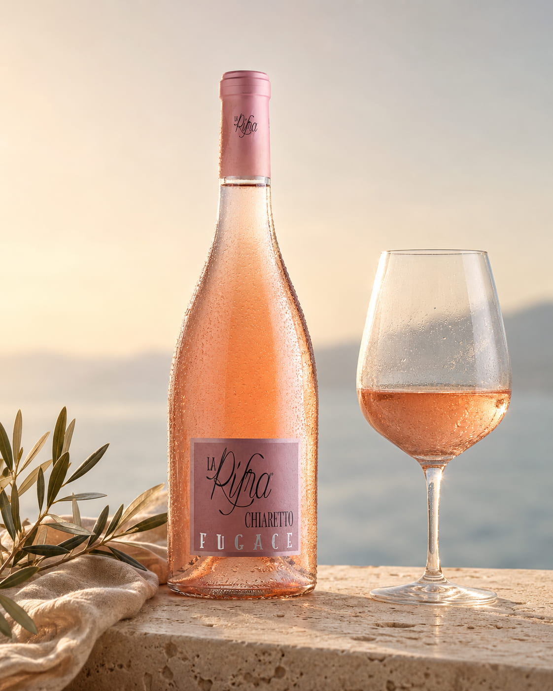 Flasche und Glas Fugace Chiaretto von La Rifra auf hellem Stein im warmen Gardasee-Licht