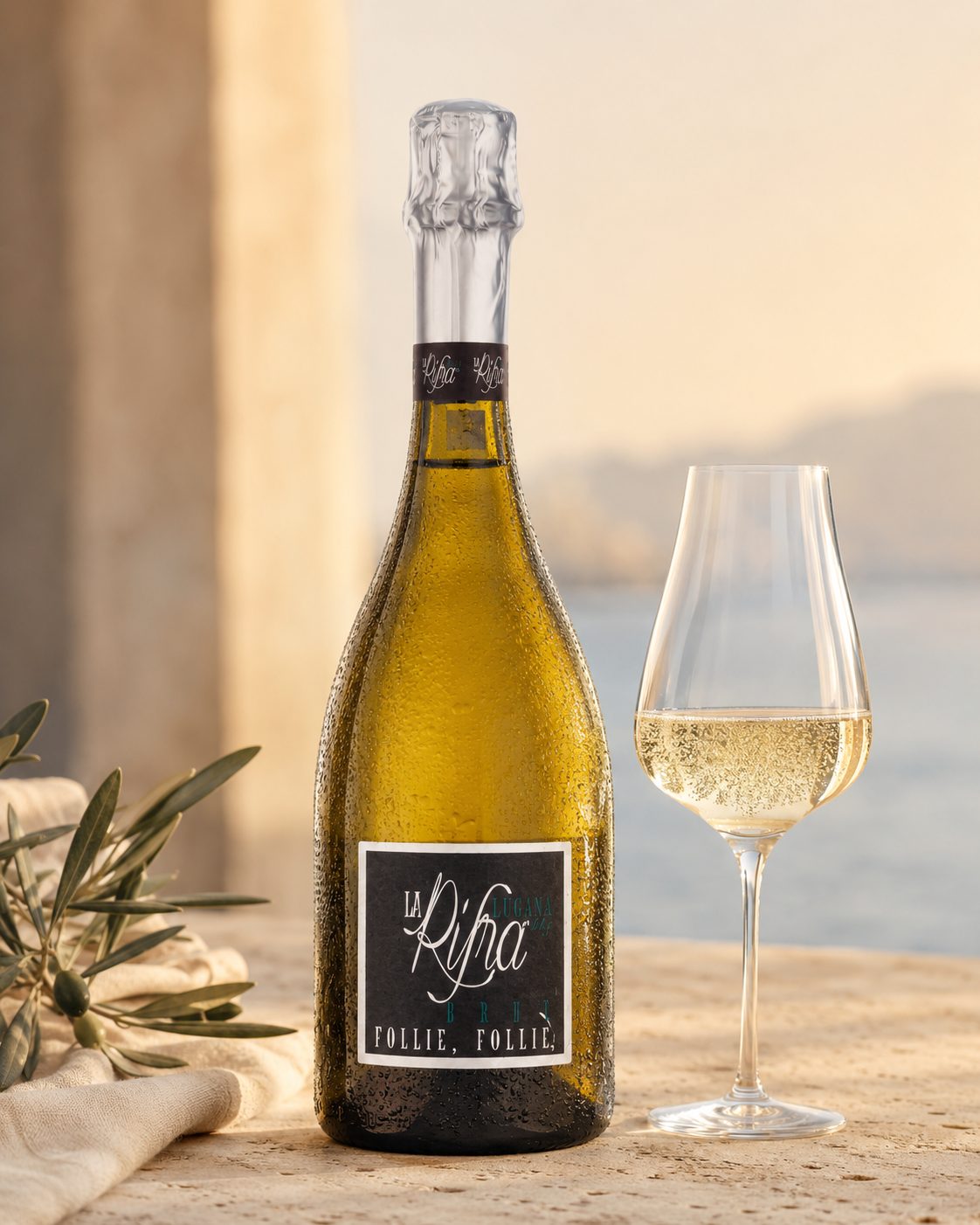 Flasche und gefülltes Glas Follie Follie auf hellem Stein – Brut Spumante von La Rifra